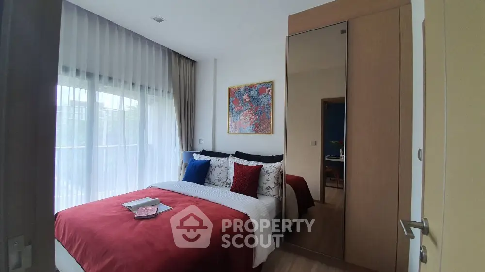 Cozy bedroom with large window and stylish decor in modern apartment