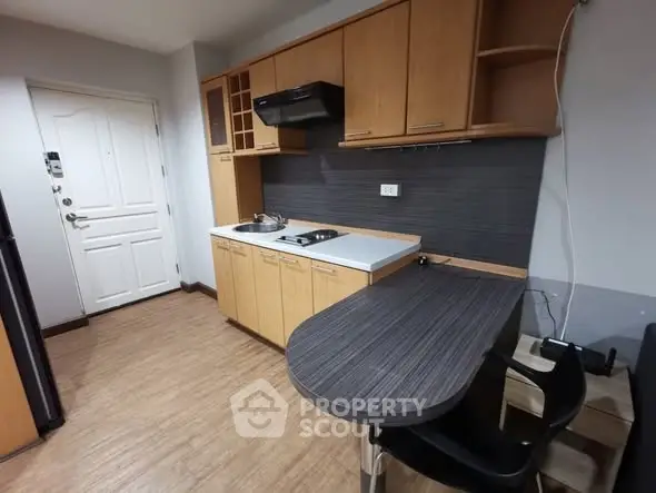Cozy kitchen with wooden cabinets and compact dining area in modern apartment