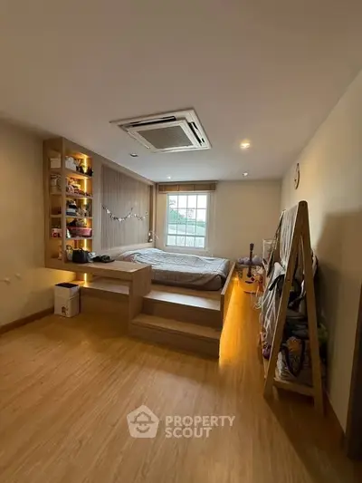 Cozy bedroom with modern wooden flooring and built-in shelves