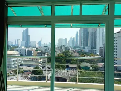 Stunning cityscape view from a modern balcony with glass railing, perfect for urban living.