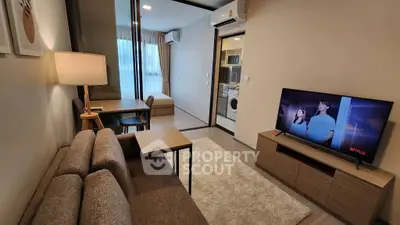 Modern living room with cozy sofa, TV, and dining area in stylish apartment.