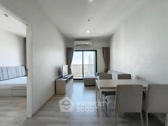 Modern living room with dining area and balcony view in a stylish apartment.