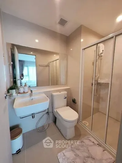 Modern bathroom with glass shower and sleek fixtures in a contemporary home.