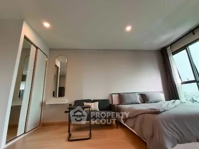 Modern bedroom with large window and stylish furniture