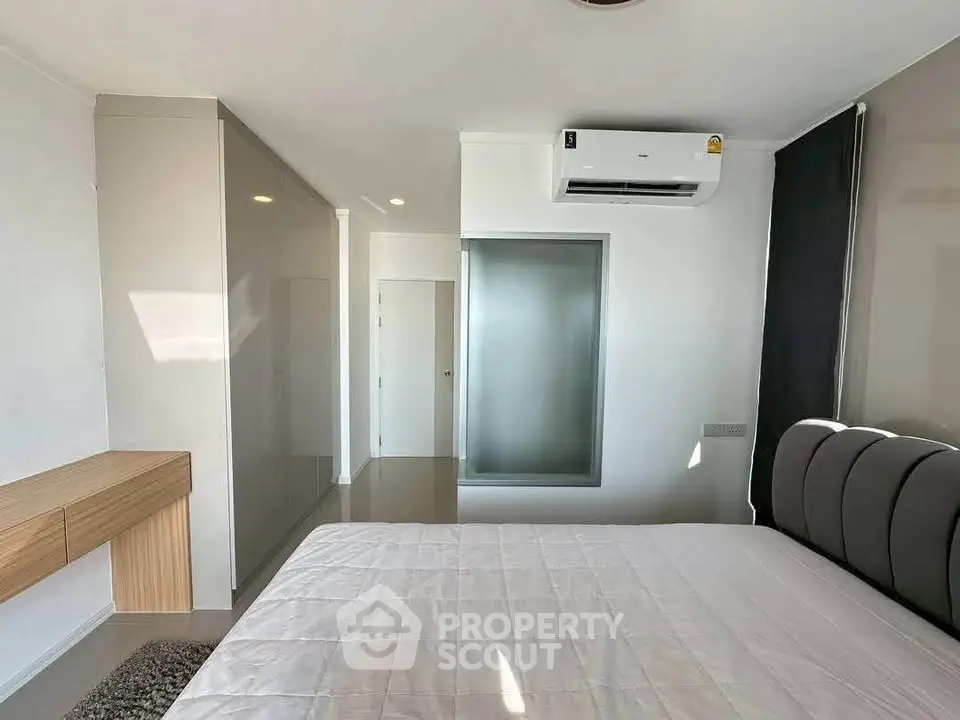 Modern bedroom with sleek design and air conditioning in a contemporary apartment.