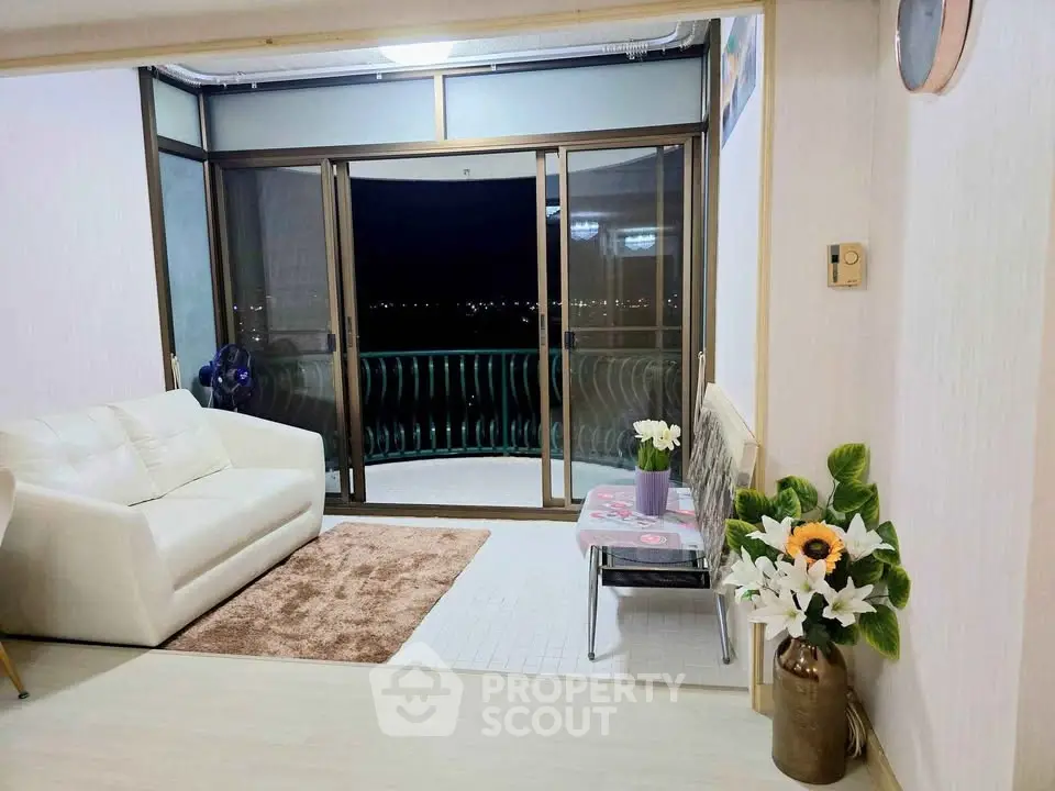 Charming living room with cozy seating and balcony access, perfect for relaxation and enjoying the view.
