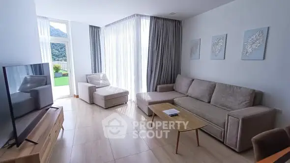 Spacious living room with modern furniture and large windows offering scenic views.