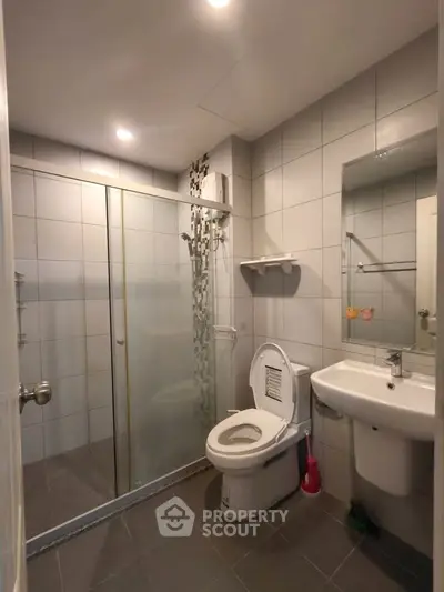 Modern bathroom with glass shower and sleek fixtures in a contemporary apartment.