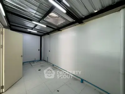 Spacious storage room with tiled floor and metal roof, ideal for versatile use.