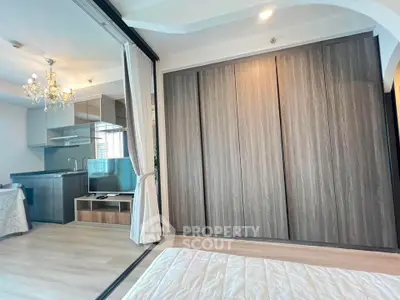 Modern open-plan living space with sleek kitchen and elegant chandelier