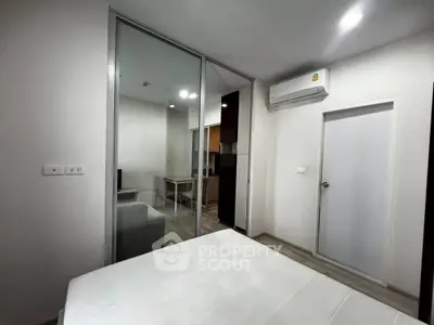Modern bedroom with glass partition and air conditioning in a stylish apartment.