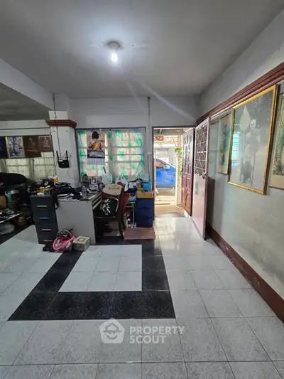 Spacious living area with tiled flooring and natural light, ideal for cozy family gatherings.