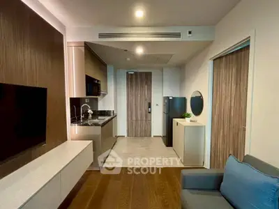 Modern apartment interior with open kitchen and cozy living area, featuring sleek cabinetry and stylish decor.