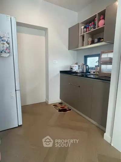 Modern kitchen with sleek cabinets and appliances, featuring a cozy and functional design.