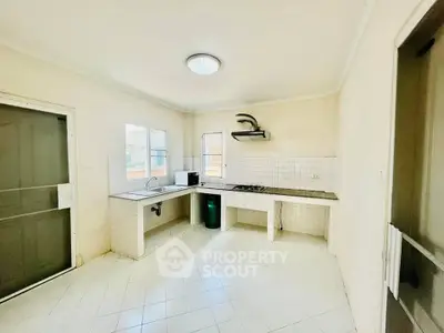 Spacious kitchen with gas stove and ample natural light, perfect for culinary enthusiasts.