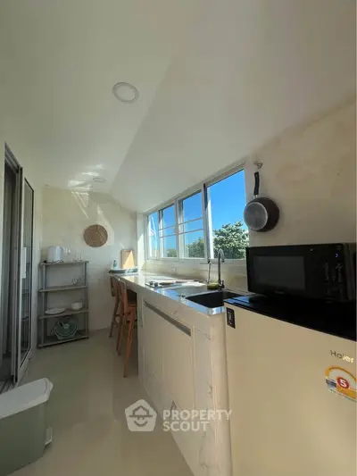 Bright kitchen with modern appliances and large windows for natural light