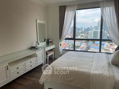 Elegant bedroom with city view, featuring classic white furniture and large window for natural light.