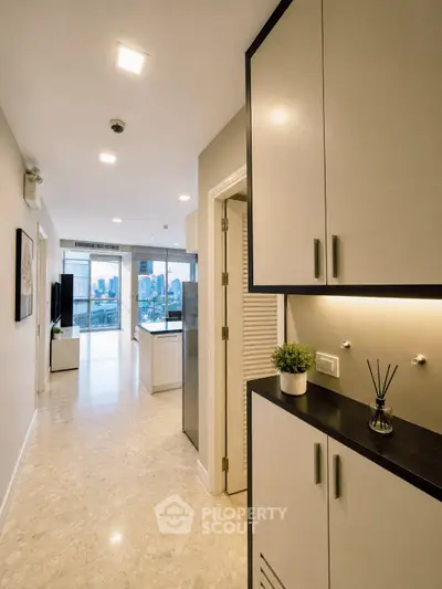 Modern apartment hallway leading to a spacious living room with city view.