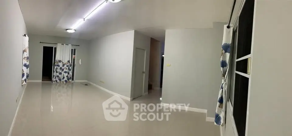 Spacious empty living room with modern lighting and large windows