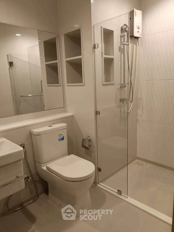 Modern bathroom with glass shower and sleek fixtures in a contemporary apartment.