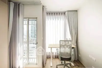 Bright study room with modern desk and chair, featuring floor-to-ceiling windows and city view.