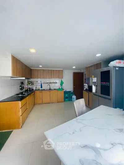 Spacious modern kitchen with sleek cabinetry and marble dining table