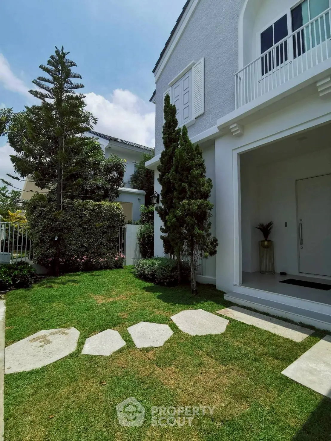 Charming exterior view of a modern house with lush garden and elegant entrance.