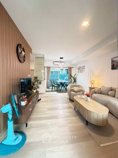 Modern living room with stylish decor, wooden flooring, and cozy seating area, perfect for relaxation and entertainment.