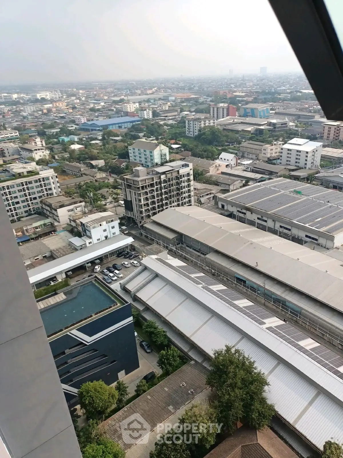 Stunning cityscape view from high-rise building with pool and urban landscape.