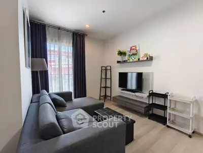 Modern living room with sleek gray sofa and wall-mounted TV, perfect for relaxation.