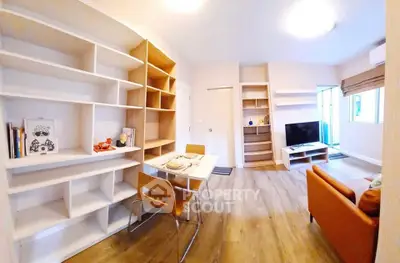 Modern living room with stylish furniture and open layout, featuring a cozy dining area and entertainment setup.