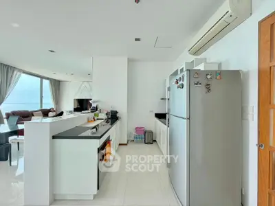 Modern open-layout kitchen with sleek appliances and spacious living area, offering a bright and airy atmosphere.