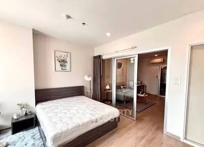 Spacious bedroom with modern decor and sliding glass doors leading to a cozy living area.