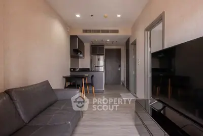Modern living room with sleek furniture and open kitchen layout in a stylish apartment.