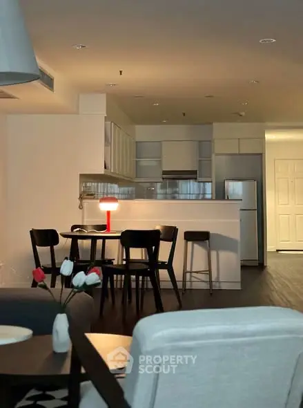 Modern open-plan kitchen and dining area with stylish furniture and ambient lighting.