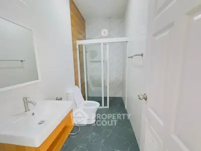 Modern bathroom with sleek design, featuring a glass shower enclosure and stylish fixtures.
