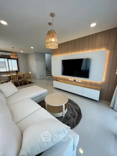 Modern living room with stylish decor and large TV, perfect for relaxation and entertainment.