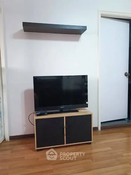 Cozy living room with wooden flooring and modern TV setup.