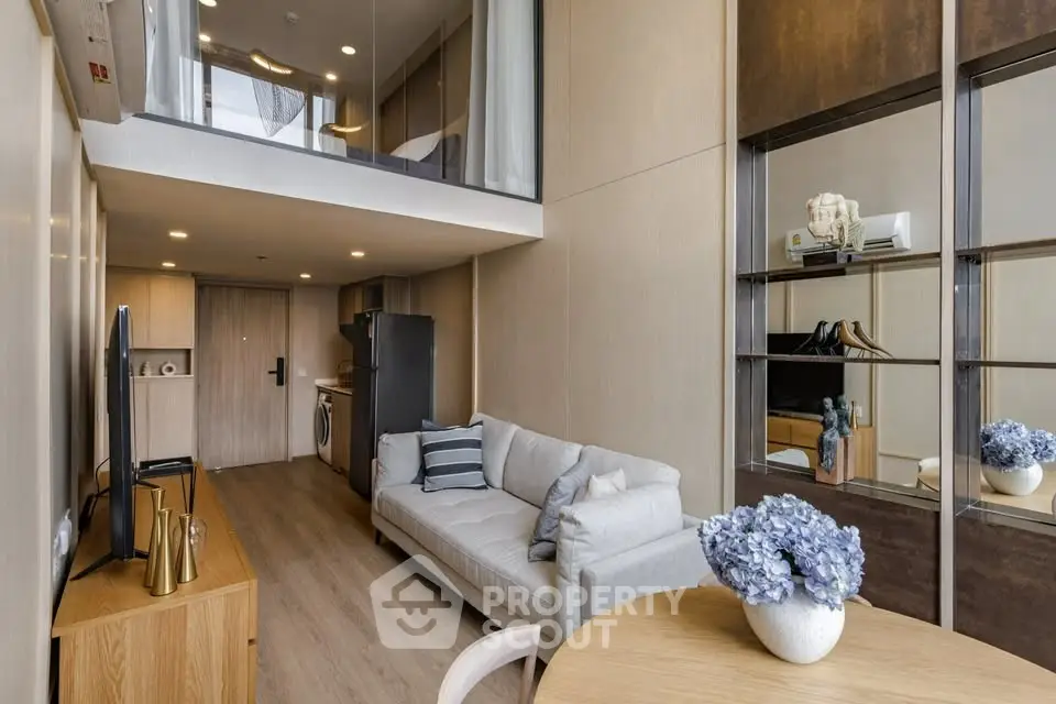 Modern living room with stylish decor and open layout, featuring a cozy sofa and elegant dining area.