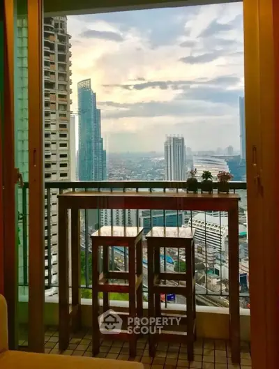 Stunning city view from a high-rise balcony with stylish wooden furniture, perfect for urban living.