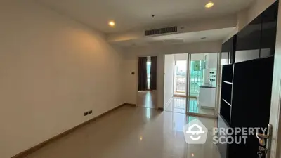 Spacious unfurnished living room with balcony access and city view