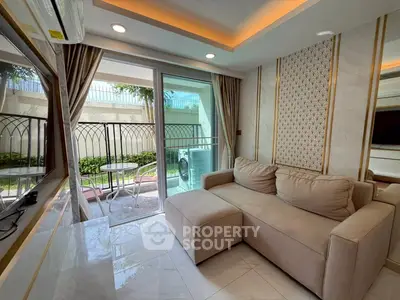 Modern living room with cozy sofa and balcony access, featuring elegant decor and natural light.