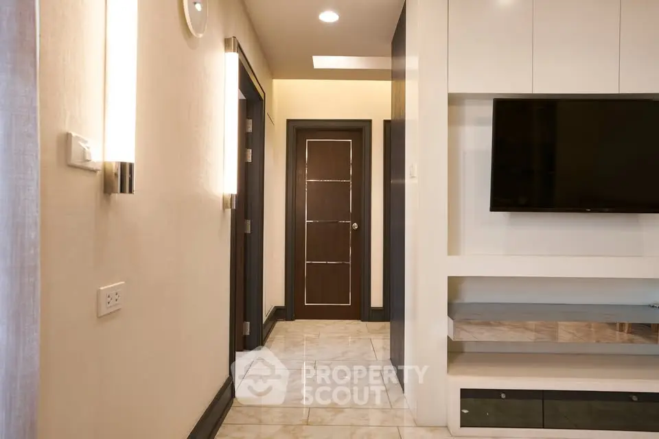 Modern hallway with elegant lighting and wall-mounted TV in a stylish apartment.