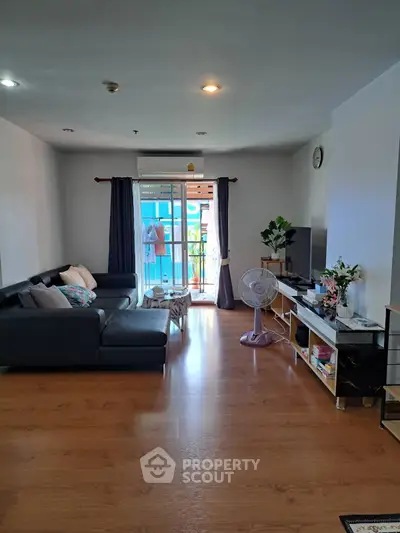 Spacious living room with modern decor and balcony access