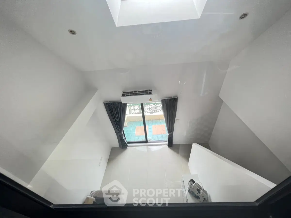 Modern loft-style apartment with high ceiling and large window for natural light.