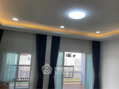 Modern living room with stylish ceiling lights and large windows leading to a balcony.