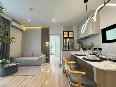 Modern open-plan living room and kitchen with stylish decor and natural light.