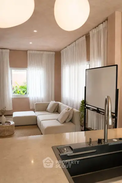 Elegant living room with modern decor and natural light, featuring a cozy sectional sofa and stylish curtains.