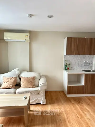 Cozy living room with modern kitchenette and wooden flooring
