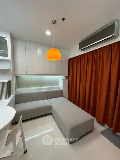 Modern living room with sleek sofa, orange curtains, and stylish lighting